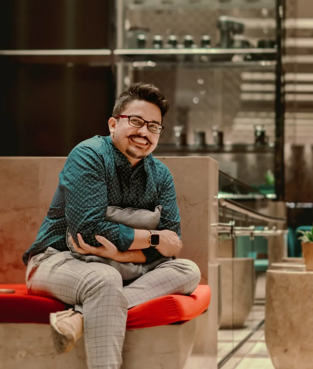 Rishav Chakraborty smiling while sitting at novotel